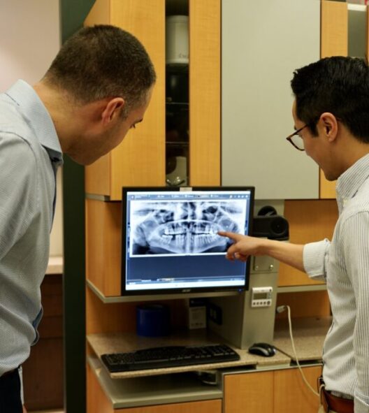 Dentist reviewing dental X-ray.