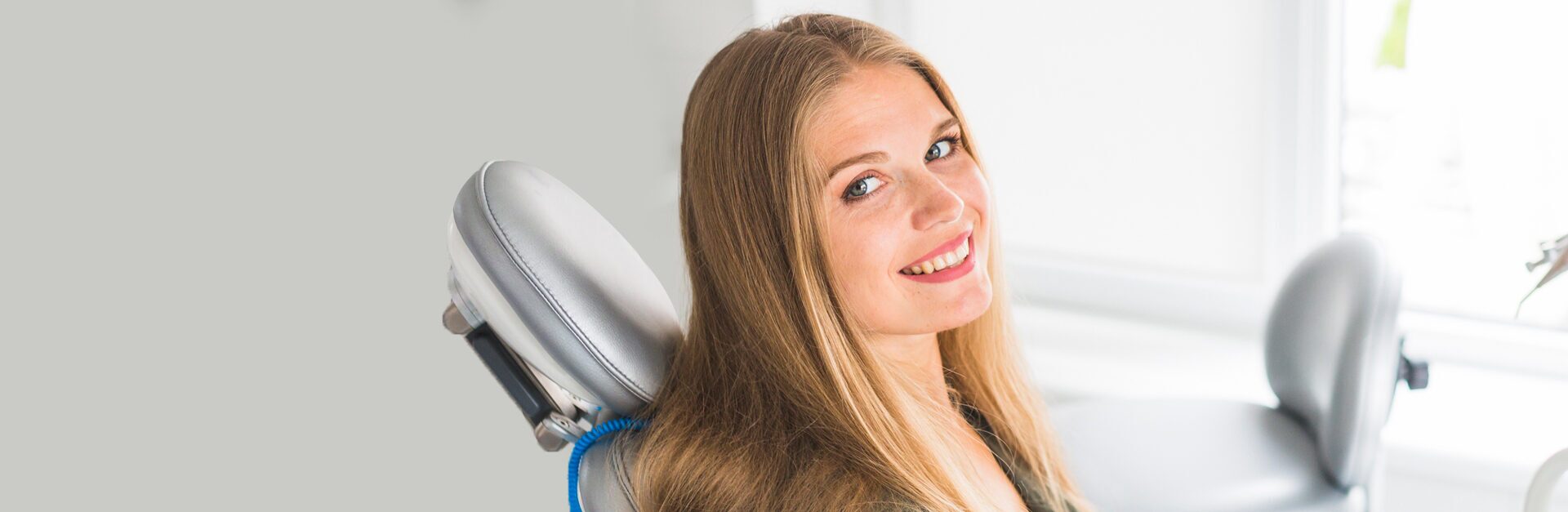 Girl siting on dental chair and smiling