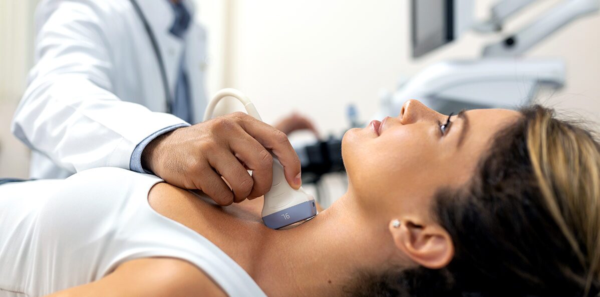 Dentist performing an ultrasound on a patient’s neck