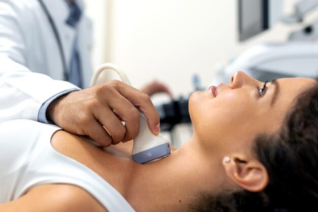 Dentist performing an ultrasound on a patient’s neck